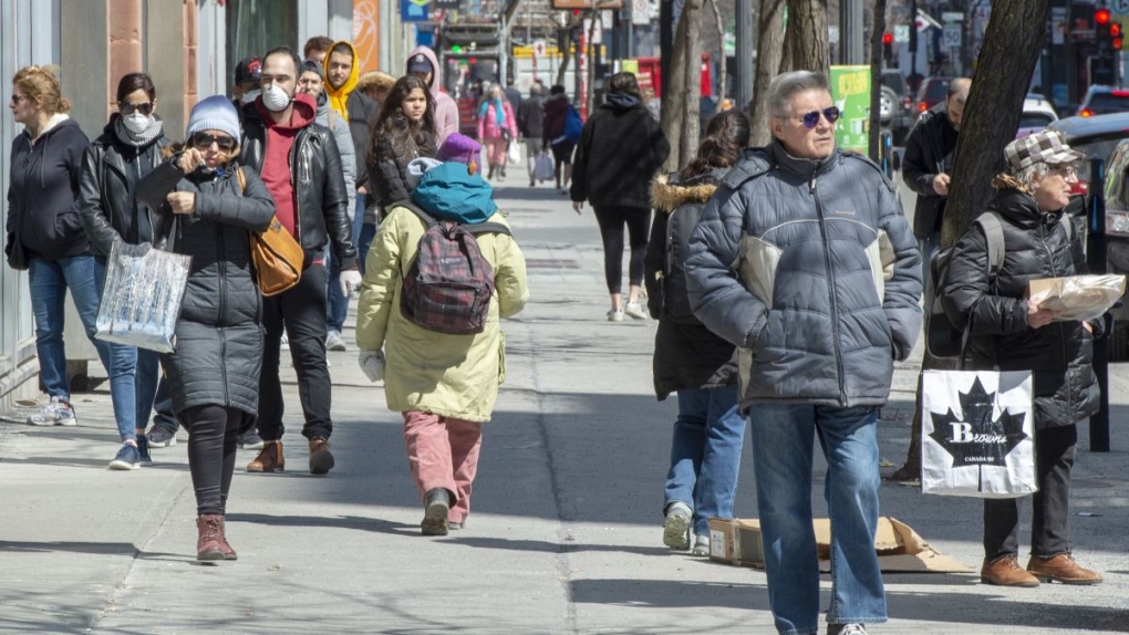 Pedestrians walk down St. Catherine Street, Monday, April 6, 2020 in Montreal. (Ryan Remiorz/THE CANADIAN PRESS)