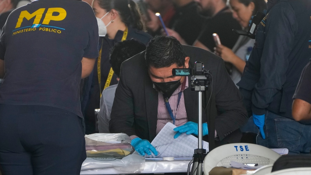 Agents from the Attorney General's office check June 25th general elections ballots during a raid at a temporary facility of the Supreme Electoral Tribunal, in Guatemala City, Tuesday, Sept. 12, 2023. (AP Photo/Moises Castillo)