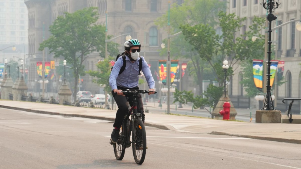 A cyclist wears a mask due to poor air quality conditions as smoke from wildfires in Ontario and Quebec hangs over Ottawa on Tuesday, June 6, 2023. (Sean Kilpatrick/THE CANADIAN PRESS)