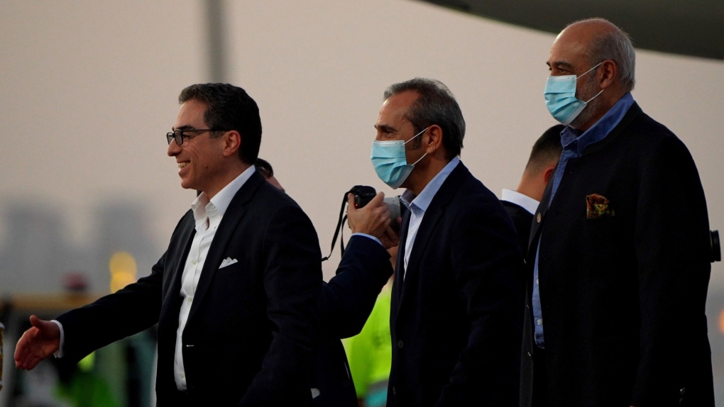 From left, Siamak Namazi, Emad Sharghi and Morad Tahbaz walk away from a Qatar Airways flight that brought them out of Tehran and to Doha, Qatar, Sept. 18, 2023. (AP Photo/Lujain Jo)