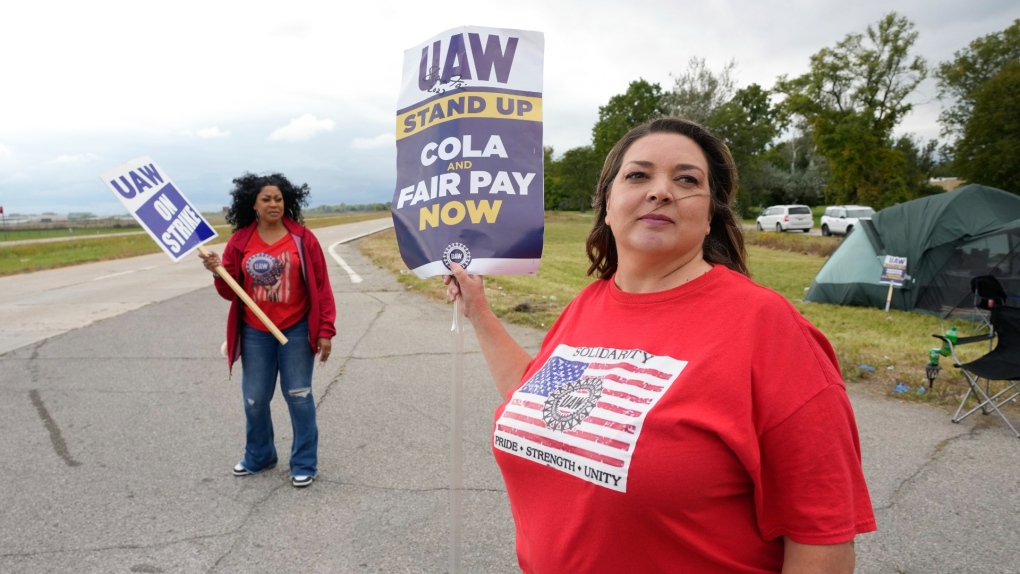United Auto Workers members Marlese Davenport, left, and Carolyn Nippa, right, walk the picket line at a General Motors parts distribution warehouse in Van Buren Township, Mich., Sept. 26, 2023. (AP Photo/Paul Sancya)