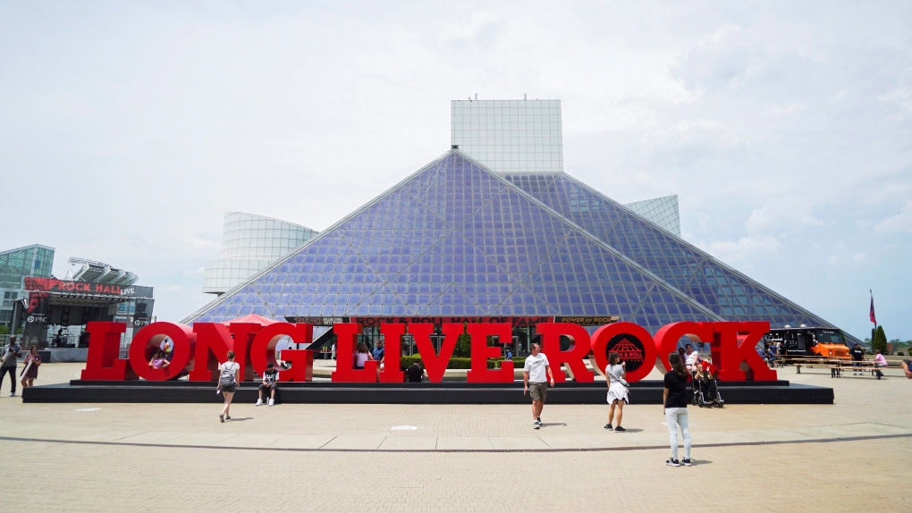 People pose for pictures outside the Rock and Roll Hall of Fame in Cleveland, Ohio, Thursday, June 29, 2017. (AP Photo/Dake Kang)