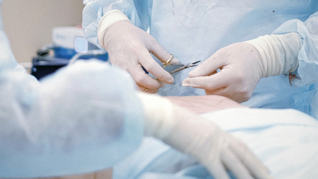 A doctor in a medical glove holds on to the groin area of a male