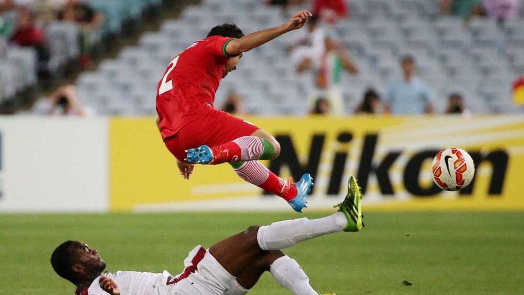 FILE - Qatar’s Mohamed Musa slides into take the ball away from Iran's Khosro Heydari during the AFC Asia Cup soccer match between Qatar and Iran in Sydney, Australia, Thursday, Jan. 15, 2015. The 18th edition of the competition kicks off in Lusail, Qatar on Friday. (AP Photo/Rick Rycroft, File)