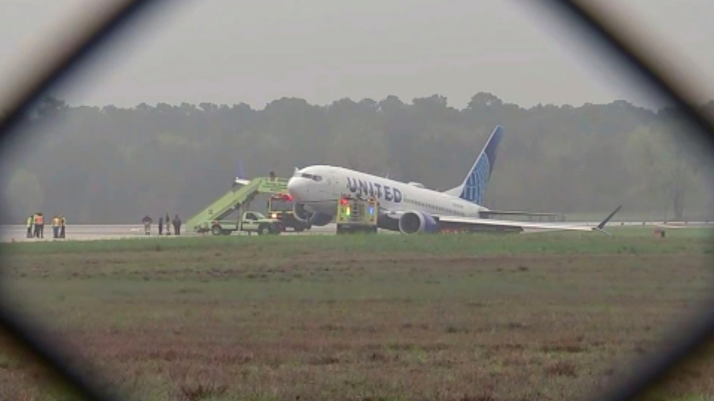 Passengers are evacuated from a United flight at George Bush International Airport, Friday, March 8, 2024 in Houston. Passengers had to be evacuated from the plane after it rolled off a runway and got stuck in the grass. (KTRK via AP)