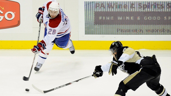 Josh Gorges scores as Penguins center Evgeni Malkin defends in Pittsburgh Saturday, Oct. 9, 2010. AP Photo/Don Wright