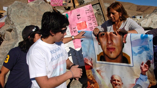 Rescued miner Richard Villarroel looks at a poster of himself as he visits the San Jose mine near Copiapo, Chile, Saturday Oct. 16, 2010. (AP / Carlos Espinoza)