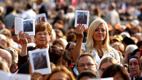 Faithful hold portraits of Canadian Brother Andre Bessette, during a Canonization Mass led by Pope Benedict XVI in St. Peter's square at the Vatican on Sunday, October 17, 2010. (AP / Pier Paolo Cito)