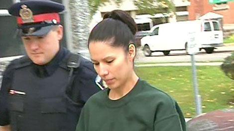 Renee Acoby is escorted by police outside the court house in Kitchener, Monday, Oct. 18, 2010.