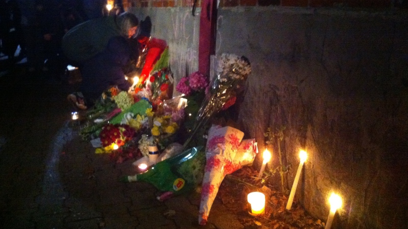 A woman places flowers by a memorial for stabbing victim Nighisti Semret in Toronto, Oct. 24, 2012. (Scott Lightfoot/ CTV Toronto)