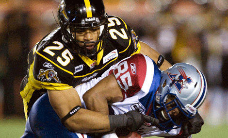 Alouettes wide receiver Brian Bratton gets tackled by Tiger-Cats linebacker Markeith Knowlton, during first half CFL action in Hamilton. (Oct. 22, 2010)
