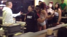The suspect sought in connection with an injury sustained during a fight at Pho Xe Lua Restaurant on Spadina Avenue is seen dressed in a costume 'SWAT' vest, centre, in this Oct. 27, 2012 image captured from video.