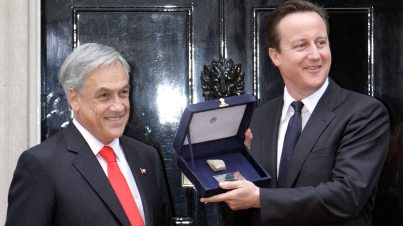 British Prime Minister David Cameron, right, poses with a piece of rock from the Chilean mine, from where 33 miners were rescued, handed to him by Chile's President Sebastian Pinera, left, at his official residence at 10 Downing Street, in central London, Monday, Oct. 18, 2010. (AP / Lefteris Pitarakis)