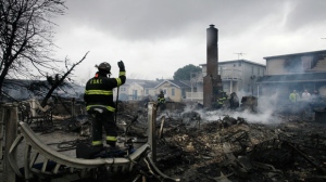 A fire fighter surveys the smoldering ruins of a house in the Breezy Point section of New York on Tuesday, Oct. 30, 2012. (AP / Mark Lennihan)