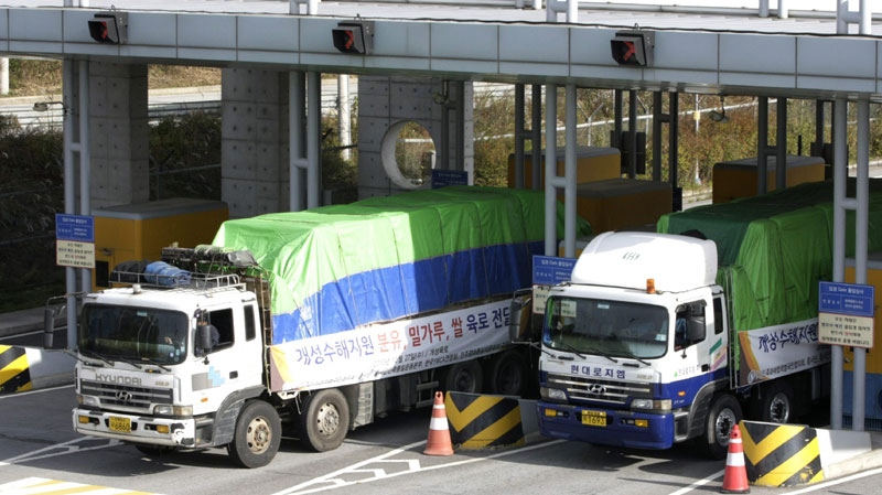 South Korean trucks loaded with sacks of flour, rice and milk powder for flood victims in North Korea pass through gates to leave for the North Korean city of Kaesong at the customs, immigration and quarantine office in Paju near the border village of Panmunjom, South Korea, Wednesday, Oct. 27, 2010. (AP Photo/Ahn Young-joon) 