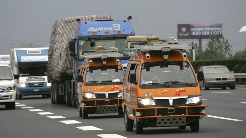 Two bright orange driverless vehicles, equipped with laser scanners and cameras to detect and help avoid obstacles, travel on the highway Tuesday Oct. 26, 2010 in Shanghai, China. (AP Photo)