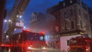 Firefighters battle a blaze on Queen Street West in Toronto early Monday morning.