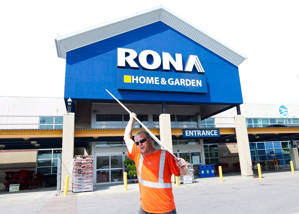 A man carries building supplies from a Rona store 