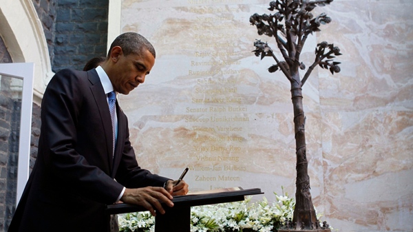 U.S. President Barack Obama signs the guest book as he visits the memorial for the Nov. 26, 2008 terror attack victims at the Taj Mahal Palace and Tower Hotel in Mumbai, India, Saturday, Nov. 6, 2010. (AP / Charles Dharapak)