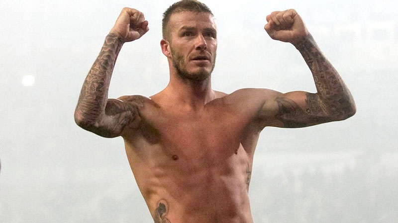 AC Milan's David Beckham celebrates jersey-less at the end of the Serie A soccer match between Juventus and AC Milan, at the Olympic stadium in Turin, Italy, Sunday, Jan.10, 2010. (AP / Alberto Ramella)