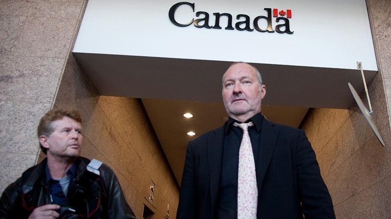 A photographer watches actor Randy Quaid leave the Immigration and Refugee Board offices following his immigration hearing in Vancouver, Monday, Nov. 8, 2010. (Jonathan Hayward / THE CANADIAN PRESS)  