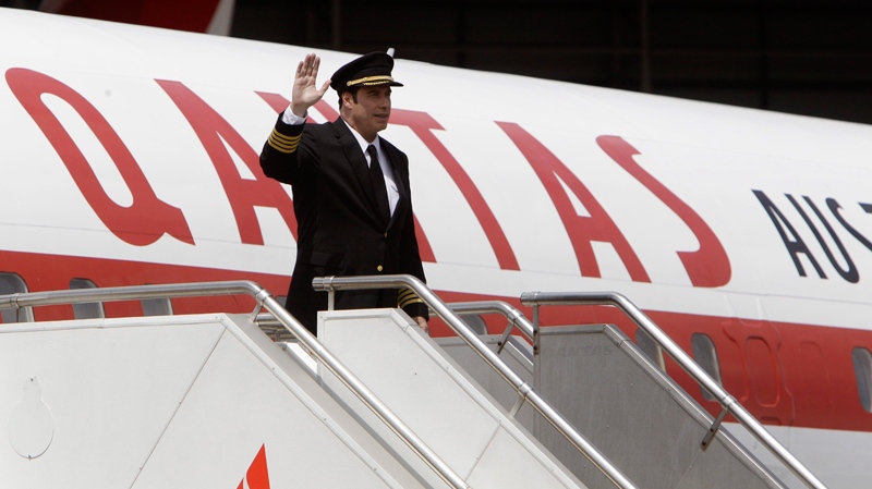 John Travolta waves as he disembarks his 707 upon arrival in Sydney to participate in the 90th anniversary of Qantas, Saturday, Nov. 6, 2010. (AP / Rick Rycroft)