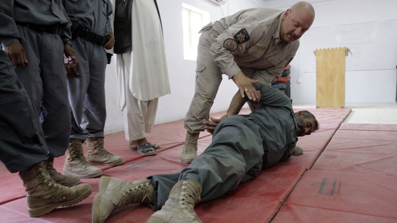 A Canadian instructor with Correctional Services Canada demonstrates how to apprehend a prisoner to Afghan prison security officers during a training at the Provincial Reconstruction Team compound in Khandahar province, south of Kabul, Afghanistan on Aug 3, 2009. (AP / Allauddin Khan)