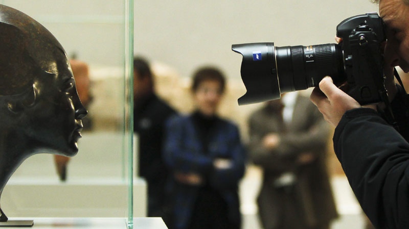 A photographer takes a picture of the sculpture 'Portrait of Anni Mewes' from 1921 by German artist Edwin Scharff during a press preview of so called 'degenerate' art in Berlin on Monday, Nov. 8, 2010. (AP Photo/Markus Schreiber)