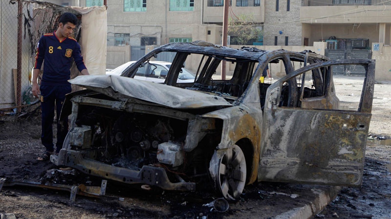 An Iraqi man inspects his destroyed car at the scene of a bomb attack in Baghdad, Iraq, Wednesday, Nov. 10, 2010.(AP Photo/Khalid Mohammed)