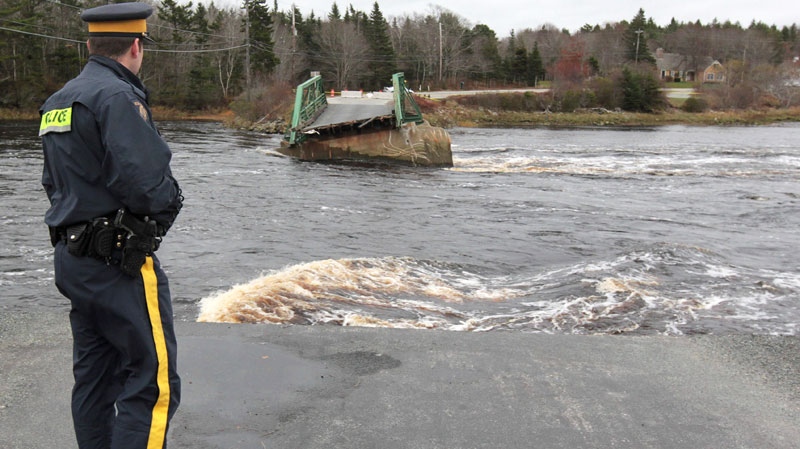 A member of the RCMP looks over the Tusket River bridge along Highway 3 in Tusket, Nova Scotia on Wednesday, November 10, 2010. (Mike Dembeck / THE CANADIAN PRESS)