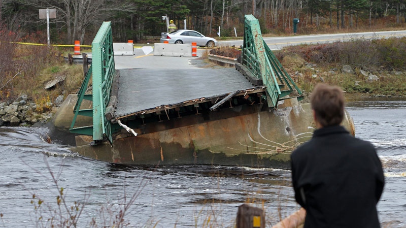 A bystander looks over the Tusket River bridge along Highway 3 in Tusket, Nova Scotia on Wednesday, November 10, 2010. (Mike Dembeck / THE CANADIAN PRESS)