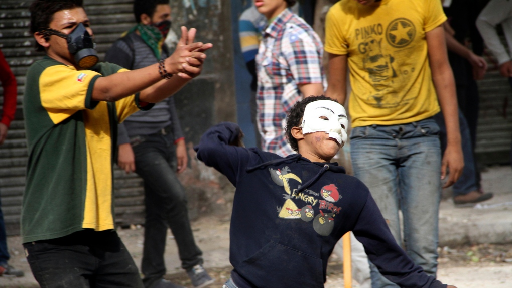 An Egyptian protester hurls a stone during protest