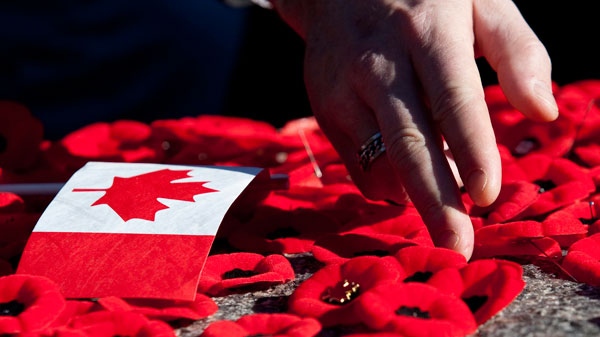 People place poppies on the Tomb of the Uknown Soldier following Remembrance Day ceremonies at the National War Memorial in Ottawa on Thursday, Nov. 11, 2010. (Pawel Dwulit / THE CANADIAN PRESS)