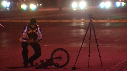 A police officer investigates the scene of a fatal bike crash.