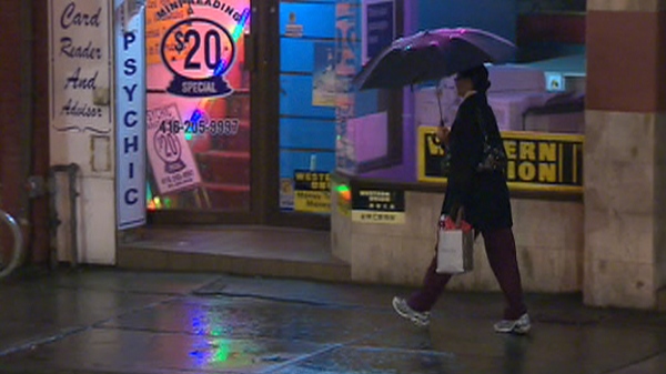 A pedestrian walks through the rain in downtown Toronto early Wednesday, Nov. 17, 2010.