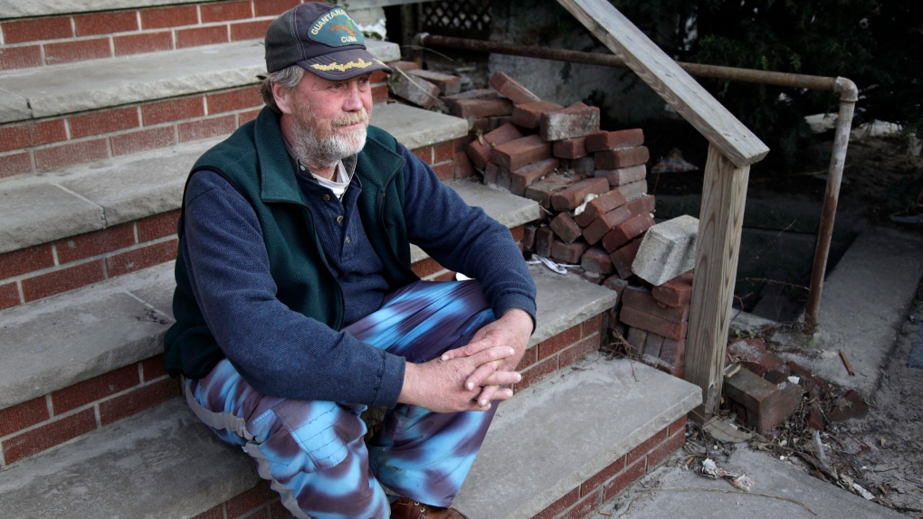 John Frawley sits on the porch of his house