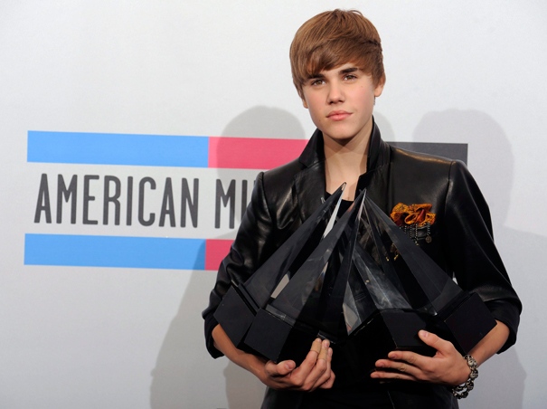 Justin Bieber hold his awards backstage at the 38th Annual American Music Awards on Sunday, Nov. 21, 2010 in Los Angeles. (AP / Chris Pizzello)