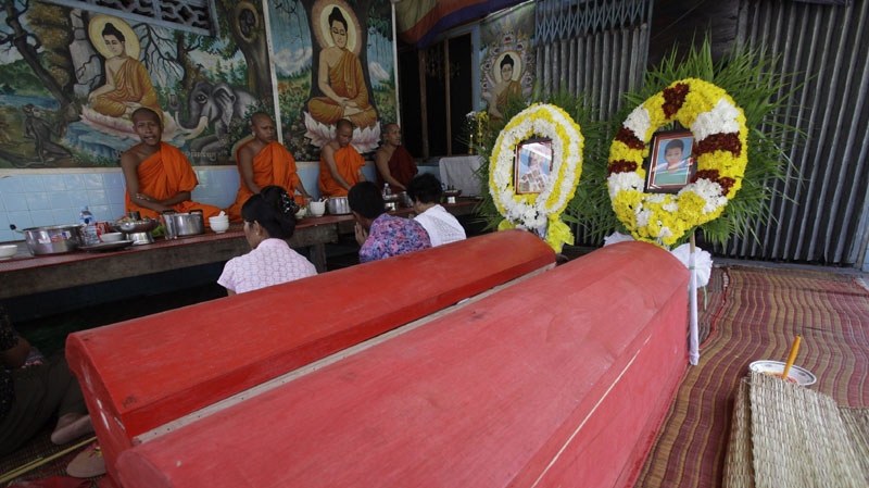 Buddhist monks pray during a funeral for Duong Hour and her son Hiep Hour, victims of Monday's stampede, at Mohamuntrei Temple in Phnom Penh, Cambodia, Wednesday, Nov. 24, 2010. (AP Photo/Sakchai Lalit) 