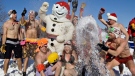 Snowbathers throw snow in the air as they gather around Bonhomme during the annual Quebec Winter Carnival snowbath Saturday Feb. 16, 2008 in Quebec City. The temperature was -13C. (Jacques Boissinot / THE CANADIAN PRESS)  