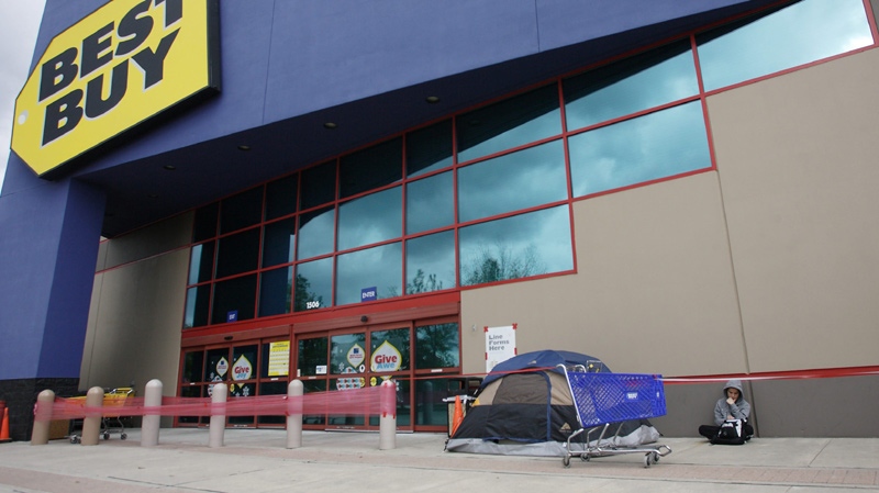 Nguyen Nguyen, 20, of Houston, sits next to his tent first in line outside of a Best Buy store in The Woodlands, Texas on Thursday, Nov. 25, 2010. (AP Photo / The Courier, Eric S. Swist)