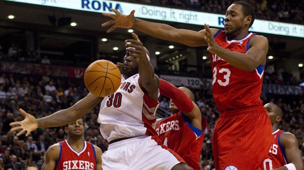 Toronto Raptors' Reggie Evans (centre) claims a rebound in front of Andre Iguodala (left) Tony Battie (centre right) and Craig Brackins (right) Philadelphia 76ers' during first half NBA basketball action in Toronto Wednesday, November 24, 2010. THE CANADIAN PRESS/Chris Young