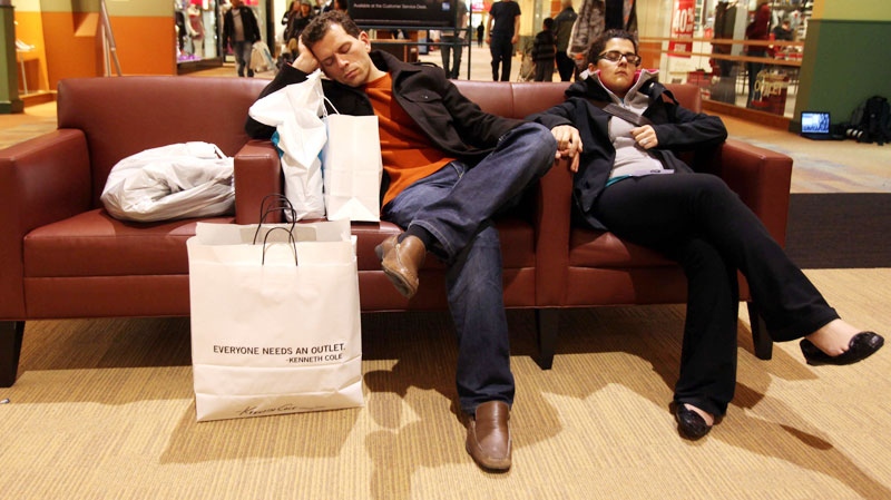 Hamid Ghadaki and his wife Hedieh Ghanbari, both from Toronto, Canada, get some sleep on comfortable leather seats during Black Friday sales at Great Lakes Crossing Outlets in Auburn Hills, MI, on Friday Nov. 26, 2010. (AP / The Detroit Free Press, Eric Seals)
