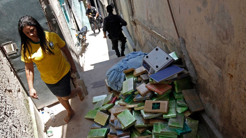 A woman walks past packages of marijuana seized during an operation against drug traffickers at the Complexo do Alemao slum in Rio de Janeiro, Brazil, Sunday, Nov. 28, 2010. (AP / Felipe Dana)