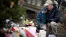 David Freedman, right, kneels with his son Zachary, 9, both of Newtown, Conn., as they visit a sidewalk memorial for the Sandy Hook Elementary School shooting victims, Sunday, Dec. 16, 2012, in Newtown, Conn.  (AP / David Goldman)