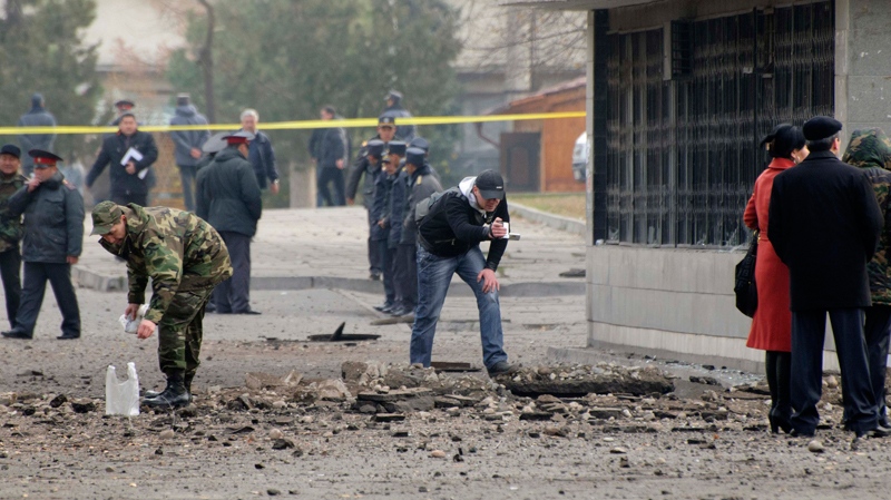 Police officers and experts examine the site of an explosion at downtown Bishkek, Kyrgyz capital on Tuesday, Nov. 30, 2010. (AP / Maxim Shubovich)