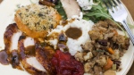 A dinner plate of cider-brined turkey with sage gravy, peach cranberry sauce, sour cream and chive mashed potatoes, sausage pecan stuffing, arugula pear salad with pomegranate vinaigrette and goat cheese and herb crusted sweet potatoes is shown in Concord, N.H. (AP /Matthew Mead)