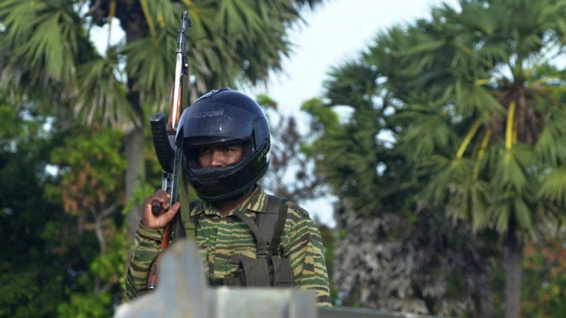 A Tamil Tiger rebel fighter patrols a street leading to the guerillas military headquarters in Mullaitivu, about 250 kilometres north of capital Colombo, Sri Lanka, Tuesday, June 14, 2005. (AP Photo/Eranga Jayawardena)