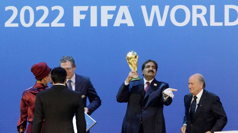 Sheikh Hamad bin Khalifa Al-Thani, Emir of Qatar, 2nd right, holds the World Cup trophy beside FIFA President Joseph Blatter after the announcement of Qatar hosting the 2022 soccer World Cup in Zurich, Switzerland, Thursday, Dec. 2, 2010. (AP / Anja Niedringhaus)