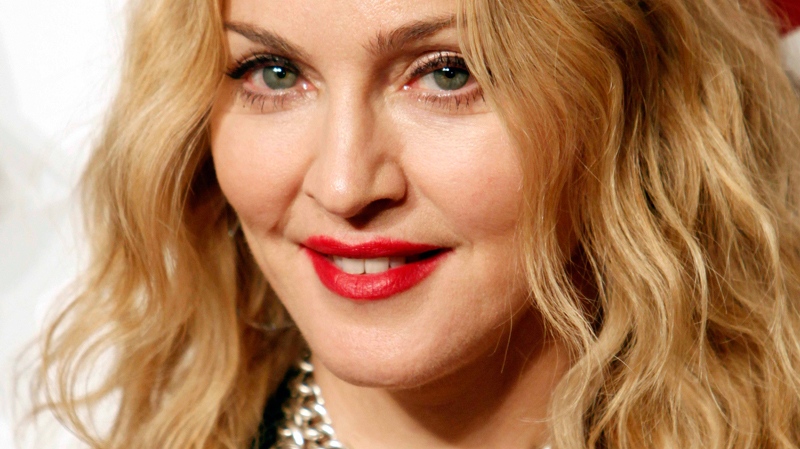 Madonna smiles as she poses for pictures during the opening of Hard Candy Fitness, her new gym in Mexico City, Monday Nov. 29, 2010. (AP / Miguel Tovar)