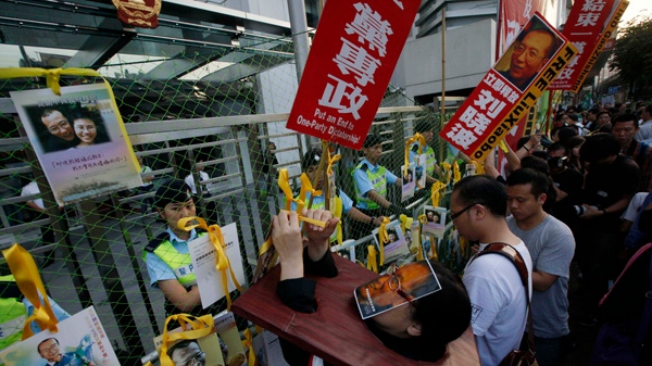 Pro-democracy protesters hang photos of jailed Chinese dissident Liu Xiaobo outside the Chinese government liaison office in Hong Kong on Sunday, Dec. 5, 2010. (AP / Kin Cheung)